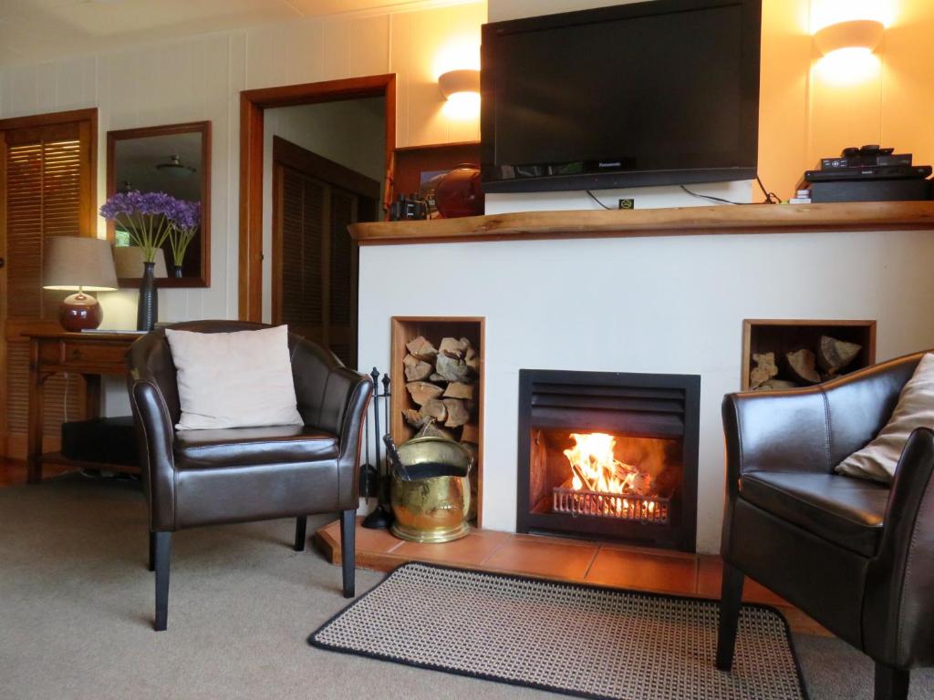 科罗曼德镇科罗曼德公寓 的客厅配有两把椅子和壁炉
