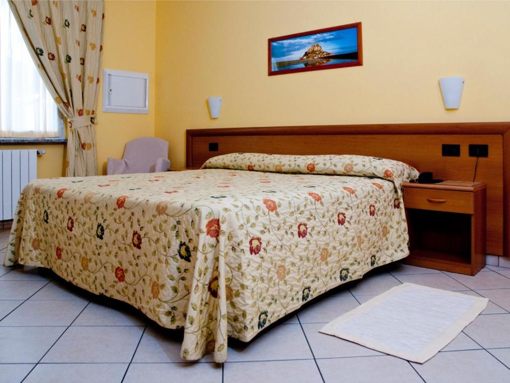 比耶拉阿加塔酒店的一间卧室配有一张带花卉床罩的床