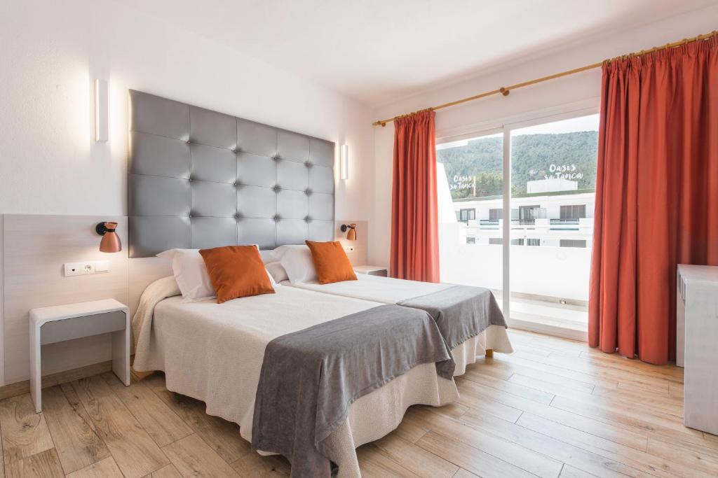 卡拉隆加Typic Oasis Sa Tanca的一间卧室设有一张大床和一个大窗户