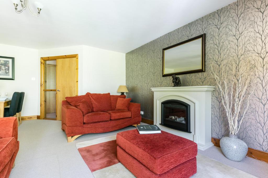 贝尔法斯特Titanic View Luxury Apartment Belfast的客厅设有红色椅子和壁炉