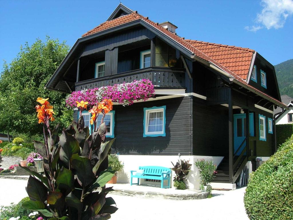 博登斯多夫豪斯顿公寓的一座带鲜花和蓝色长凳的黑色房子