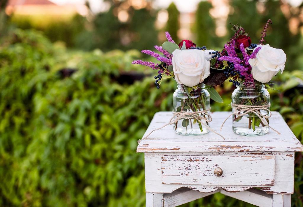 波伊奥卡萨奥姆诺旅馆的两瓶玻璃花瓶,桌子上放着鲜花