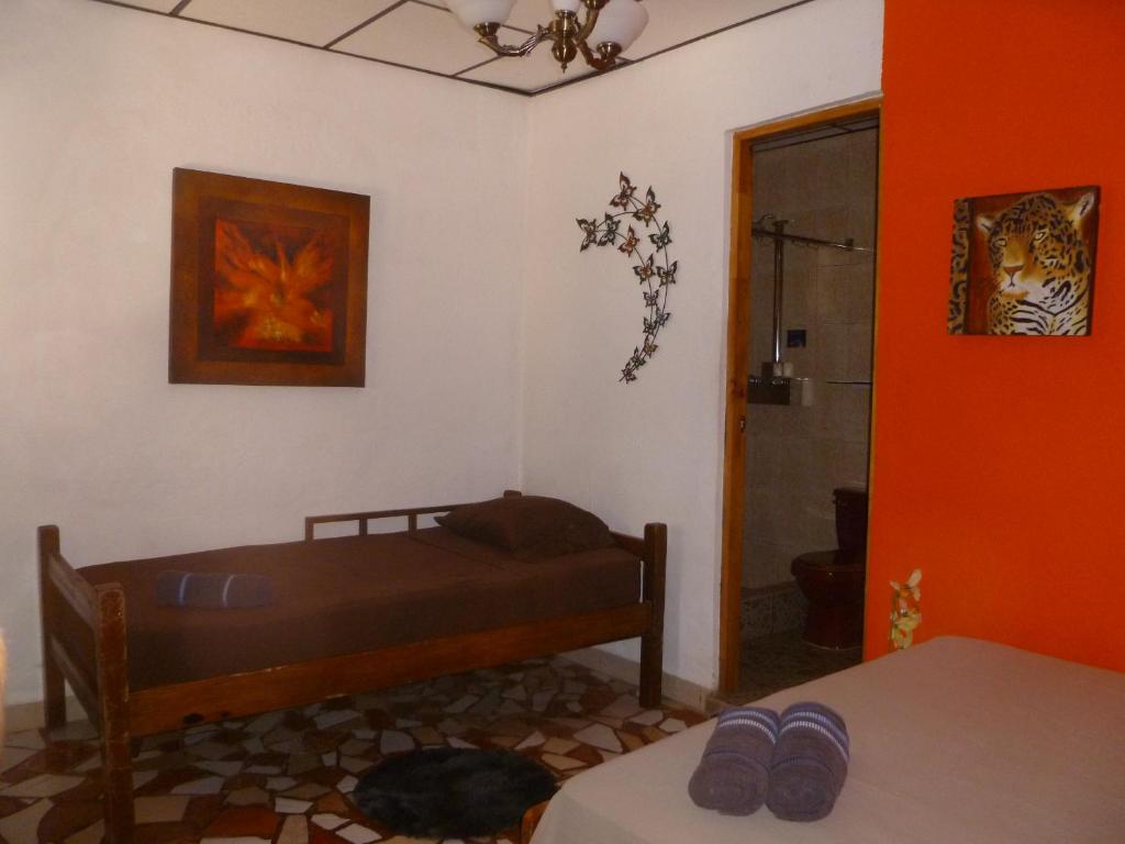 Puerto LindoHostel Wunderbar的一间设有床铺的卧室,位于一个拥有橙色墙壁的房间