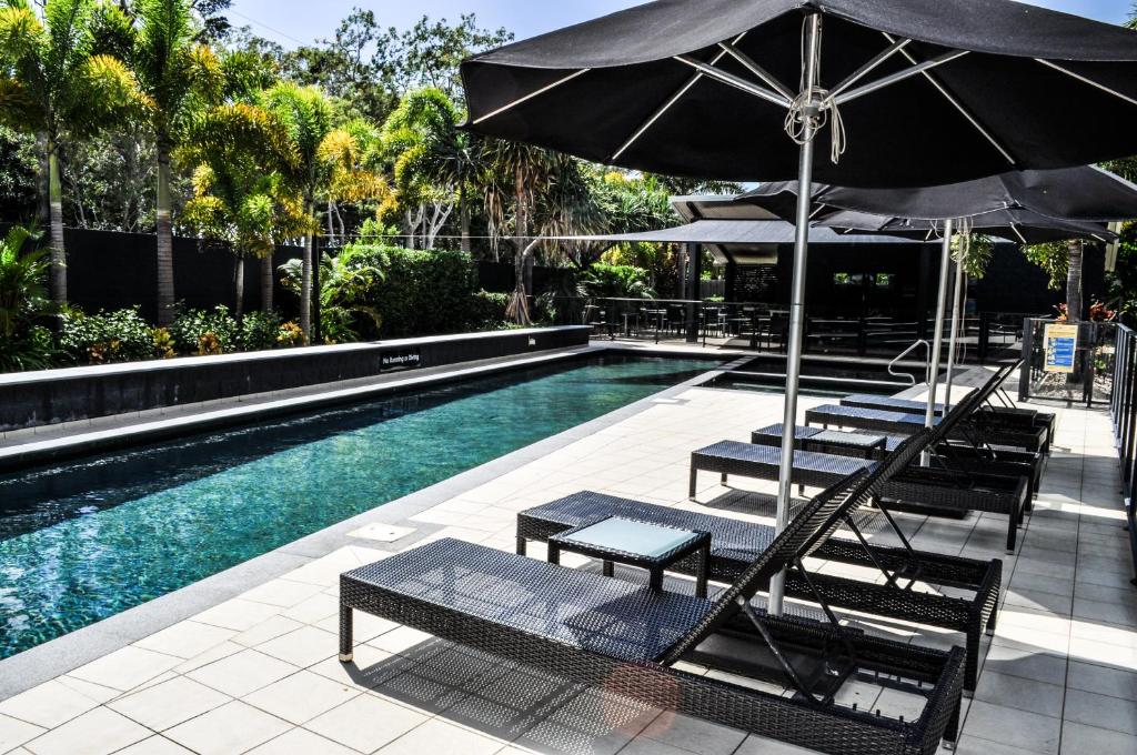 赫维湾海湾公寓酒店的一个带躺椅和遮阳伞的游泳池