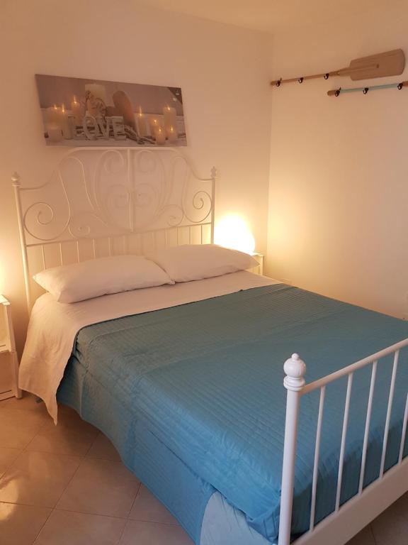 莫诺波利Casa Vacanza La Conchiglia的一间卧室配有一张白色的床和蓝色的毯子