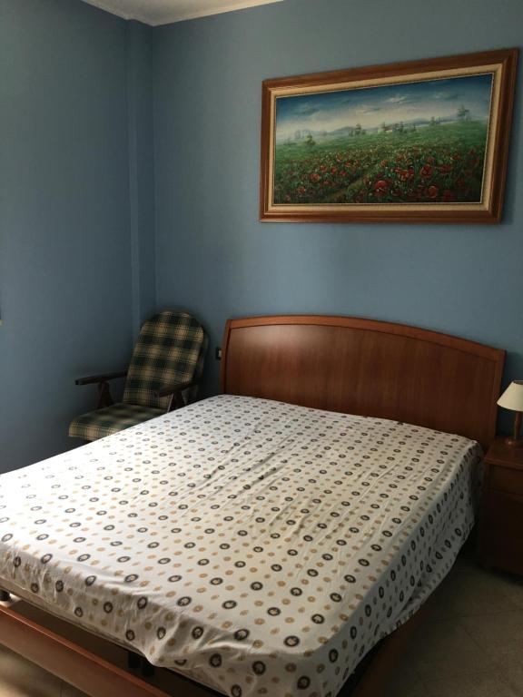 卡斯特拉巴特滨海Casa Villaggio的卧室配有一张床,墙上挂有绘画作品