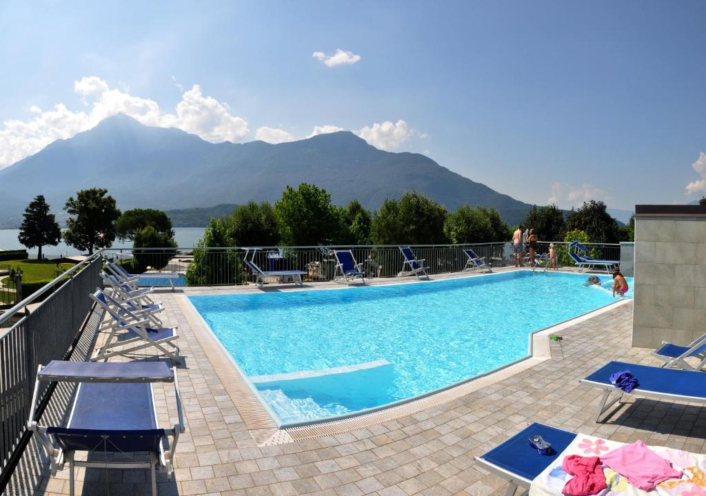 多马索露营维拉吉奥天堂酒店的一个带椅子的游泳池,背景是山脉