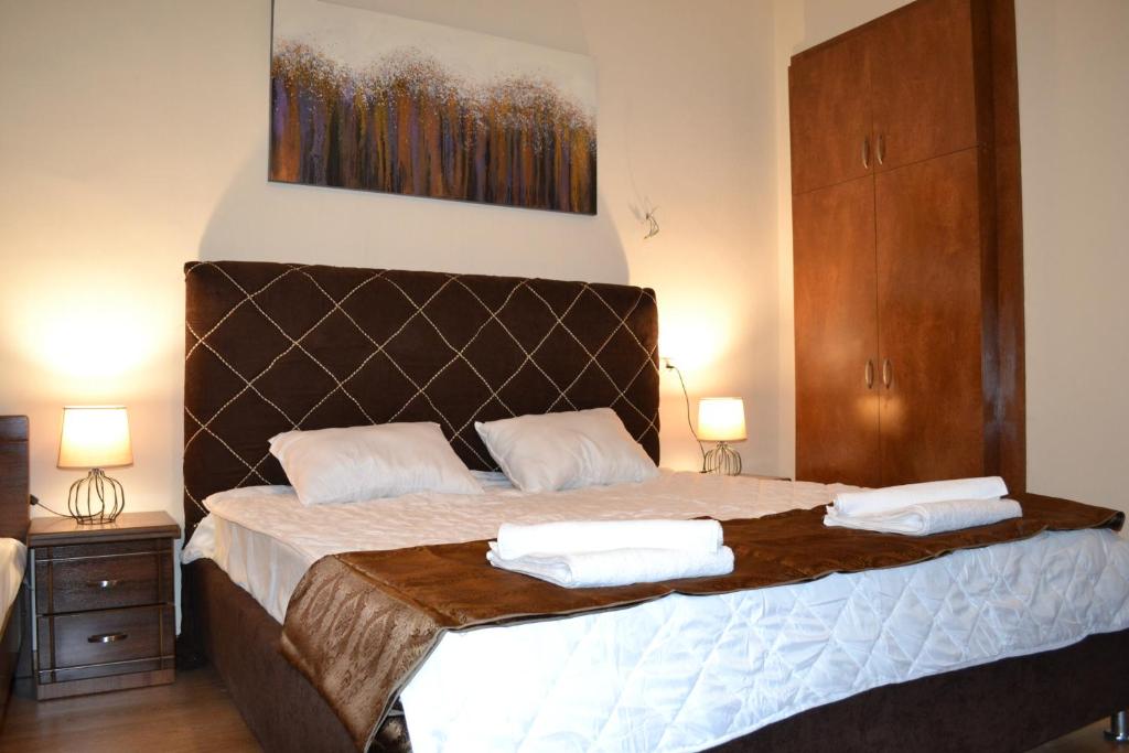 第比利斯Tbilisi Apartment 2的一间卧室配有一张大床和两条毛巾
