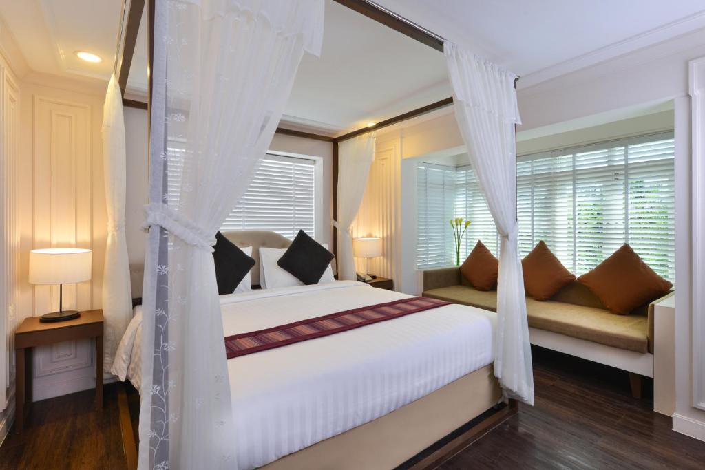 曼谷暹罗香榭丽舍大街特色酒店的卧室配有白色的床和窗户。