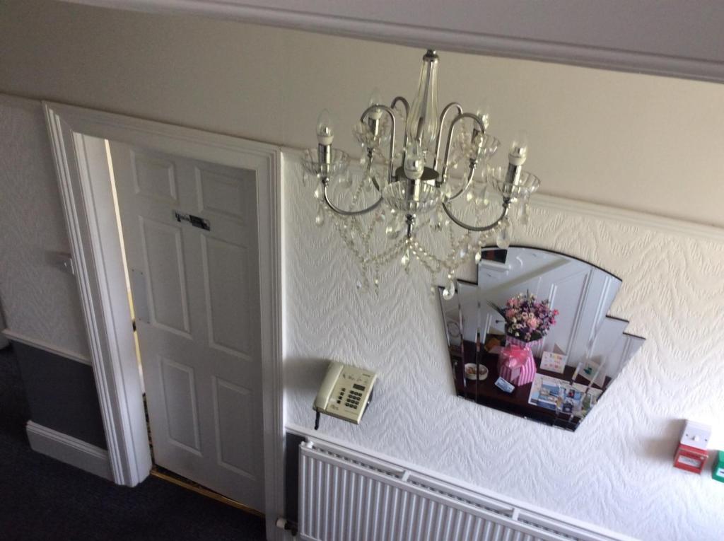 普里茅斯Alma Lodge Guest House的挂在墙上的吊灯和镜子