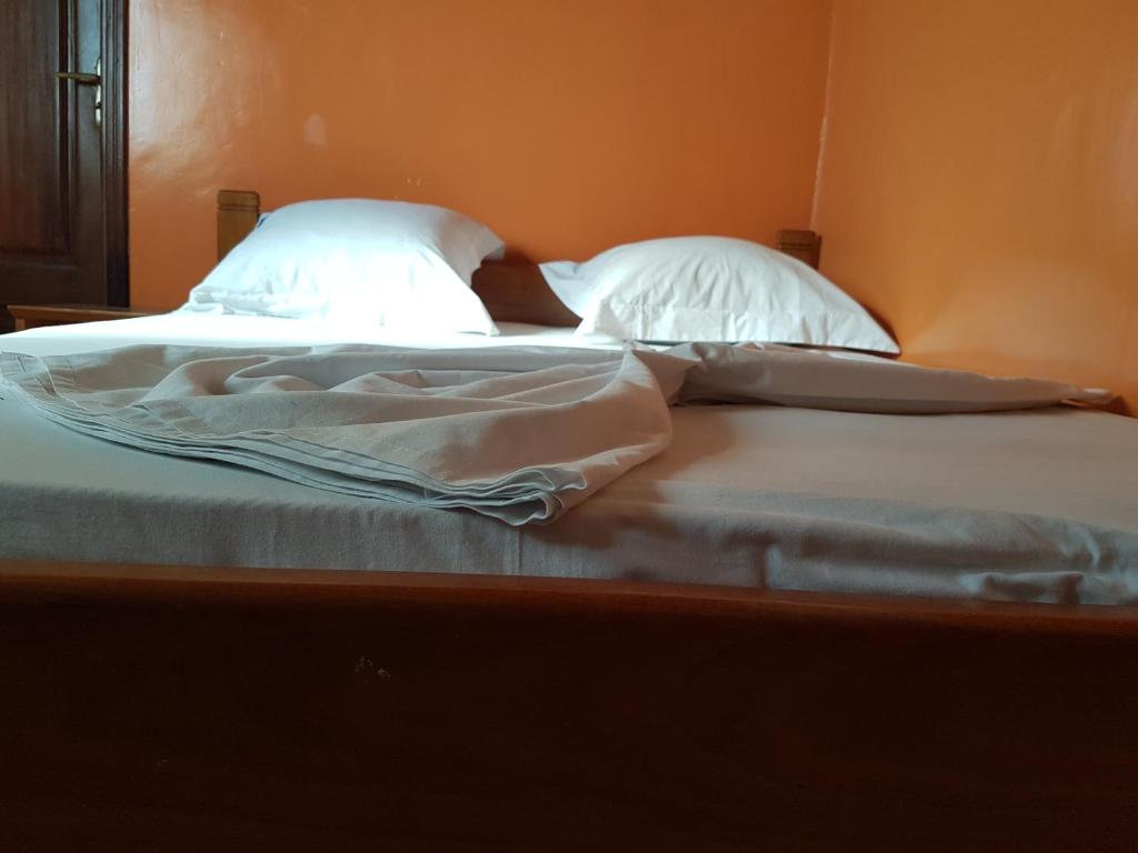 杜阿拉Maison Rose的卧室内的两张床,配有白色床单和枕头