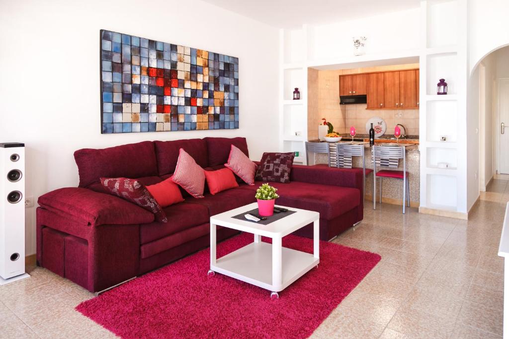 卡门港Apartamento Filla的客厅配有红色沙发和白色桌子