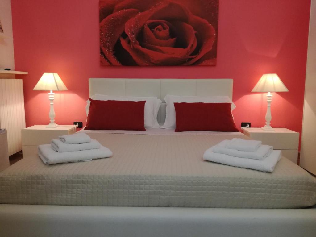 塔维亚诺Casa del Corso的一间卧室配有一张红色墙壁的床和两盏灯。