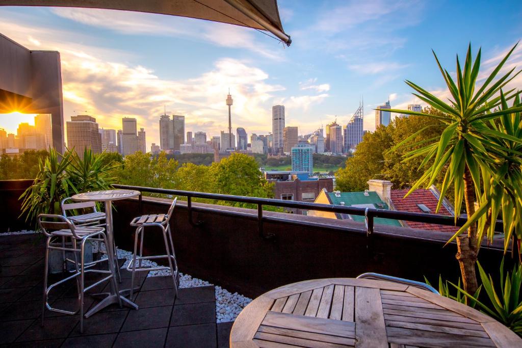 悉尼Sydney Potts Point Central Apartment Hotel Official的阳台配有桌椅,享有城市天际线