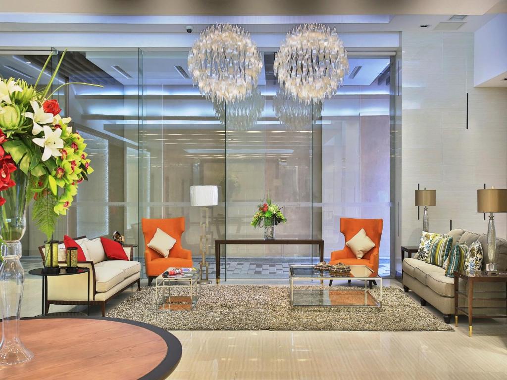 马尼拉Valero Grand Suites by Swiss-Belhotel的客厅配有两张沙发和一个吊灯。