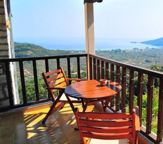 帕纳基雅Agnanti Studios的观景阳台配有一张木桌和椅子。