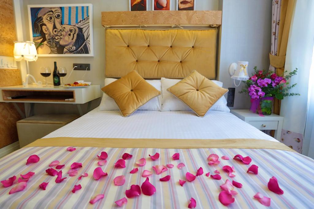 伊斯坦布尔加斯特酒店的一张床上有粉红色玫瑰花瓣的床