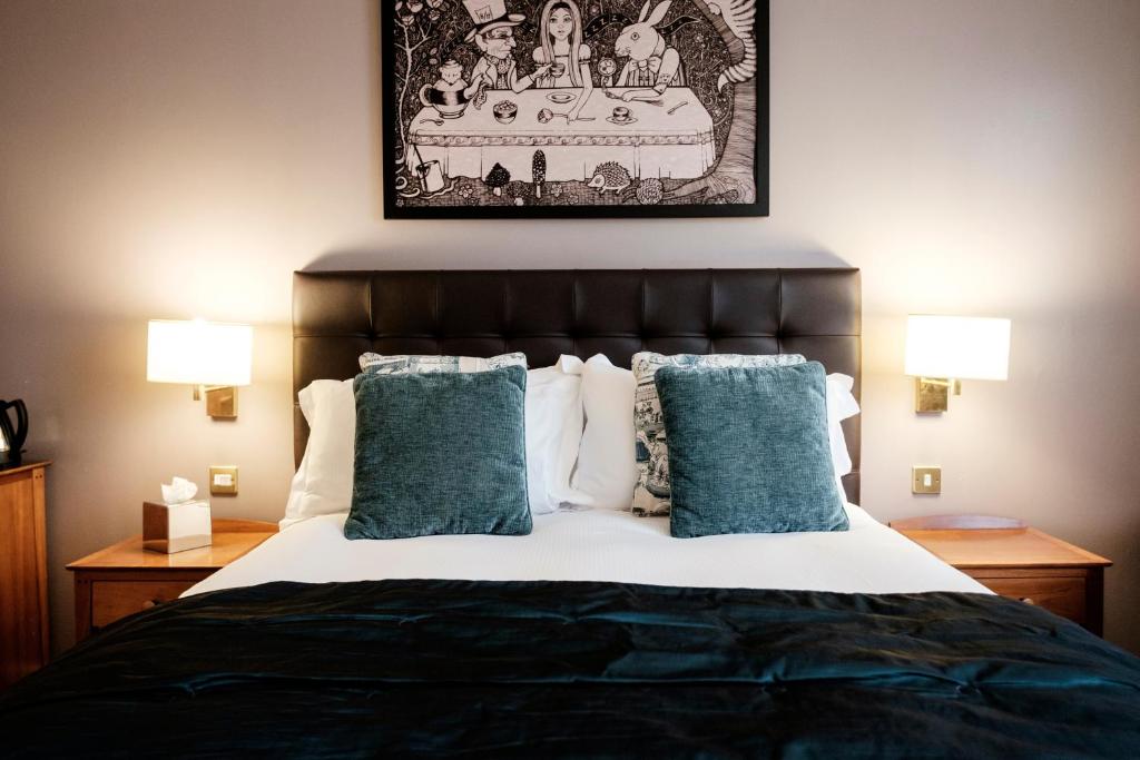 伦敦富勒疯帽子酒店的一间卧室配有一张带蓝色枕头的大床