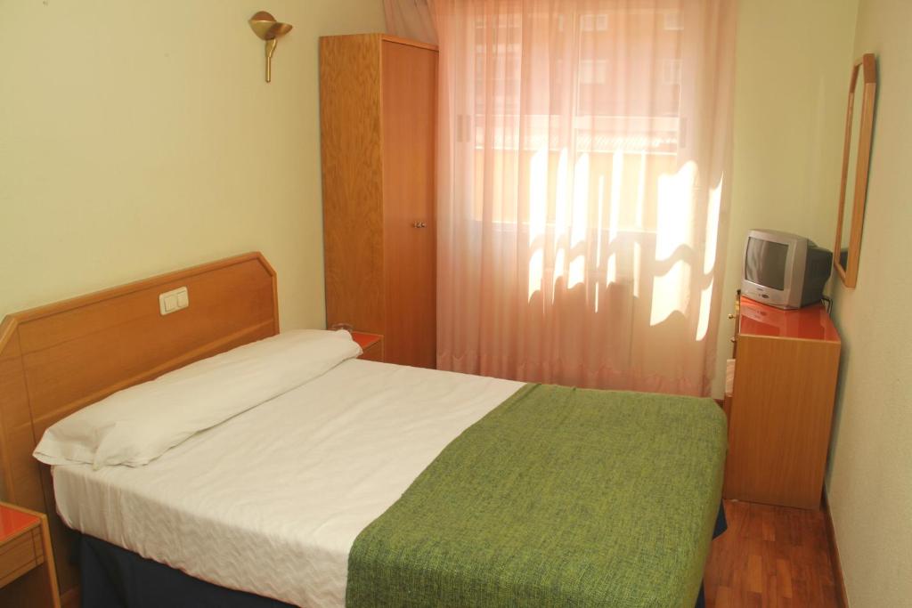 布尔戈斯阿尔兰松旅馆的一间小卧室,配有一张床和电视