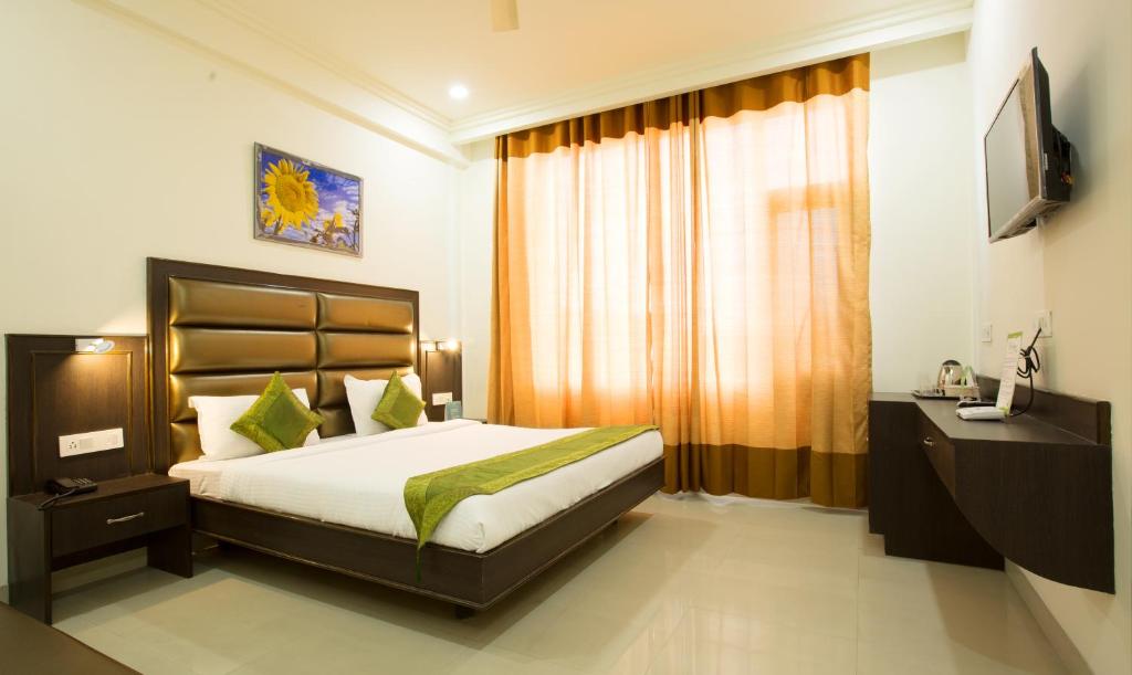 阿姆利则Treebo Trend Dee Intercontinental Amritsar的一间卧室配有一张床和一台电视