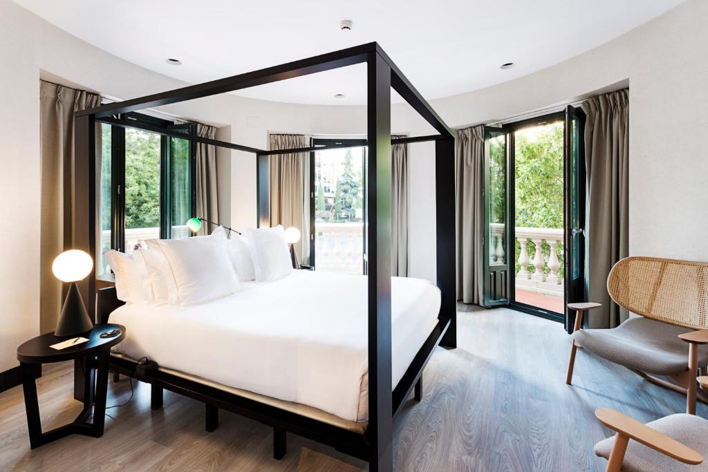 马德里一期一会鲁查纳22号酒店的卧室设有白色的床和大窗户