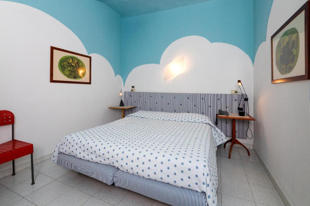 蓬泰代拉伊尔法尔盖托酒店的卧室配有白色的床和红色椅子