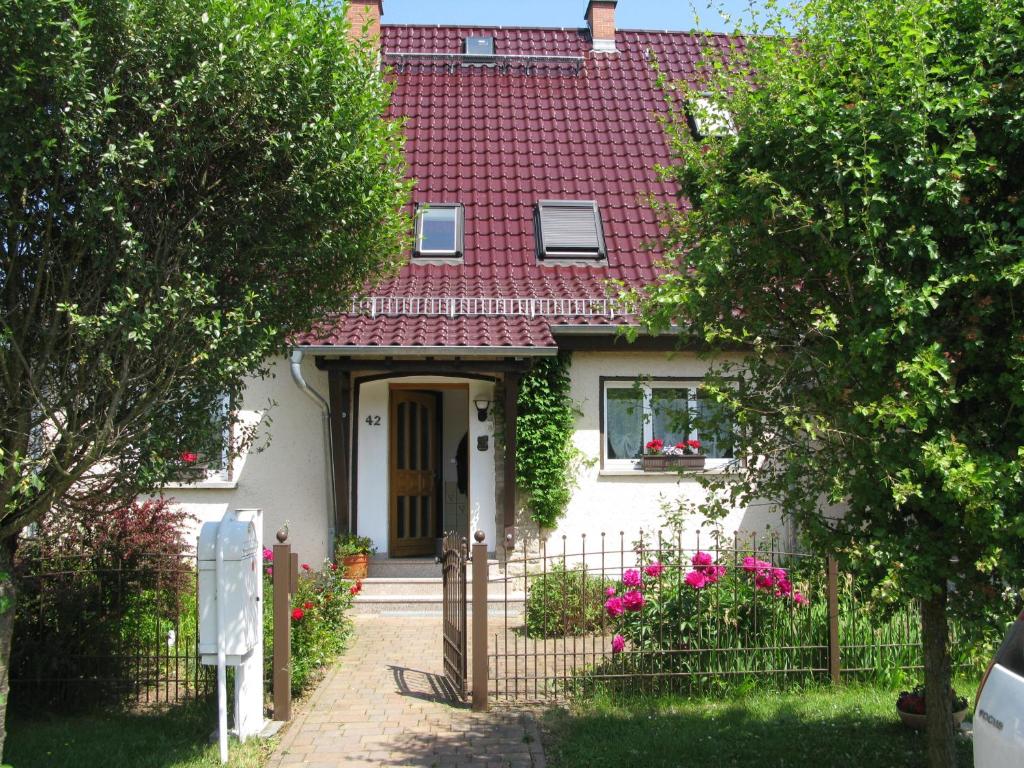 GroßschwabhausenFewo Weidenhof的白色的房子,有红色的屋顶和门