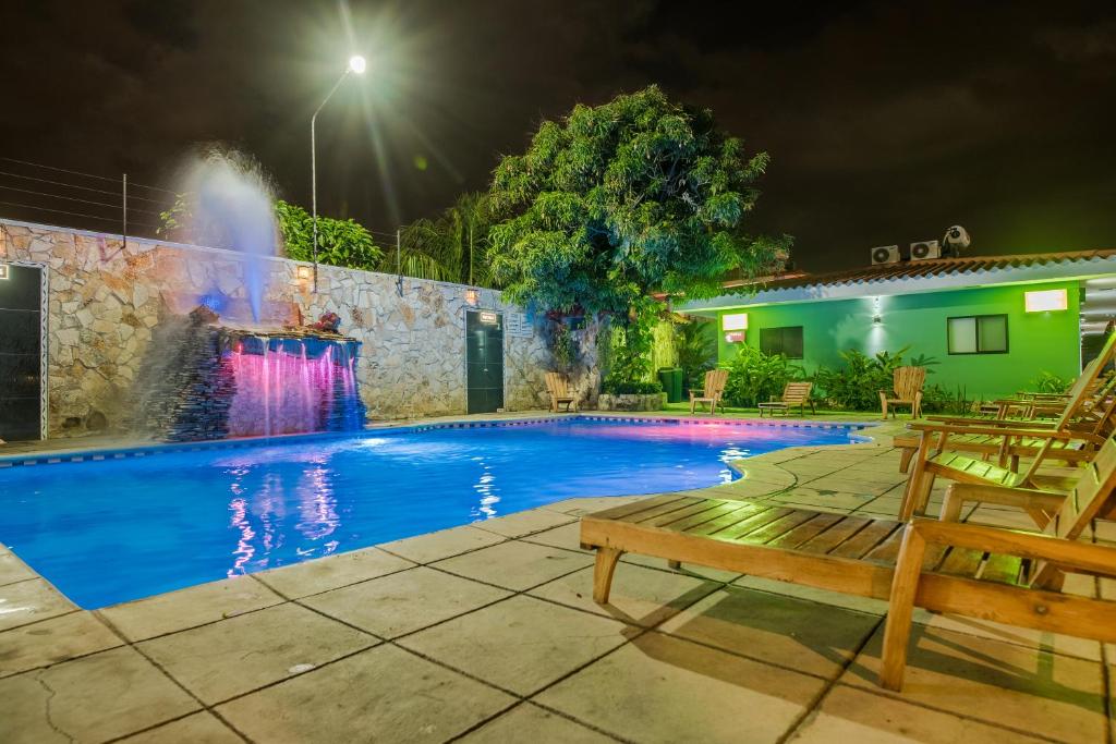 格拉纳达Hotel Los Chilamates的游泳池在晚上设有喷泉