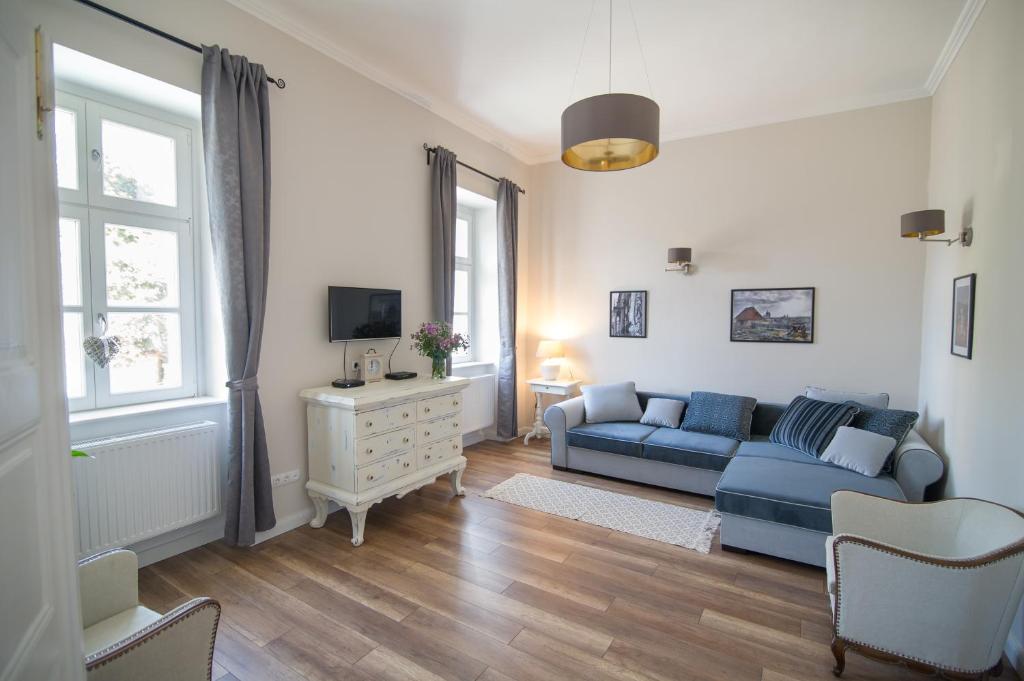 埃格尔Bródy Apartman的客厅配有蓝色的沙发和电视