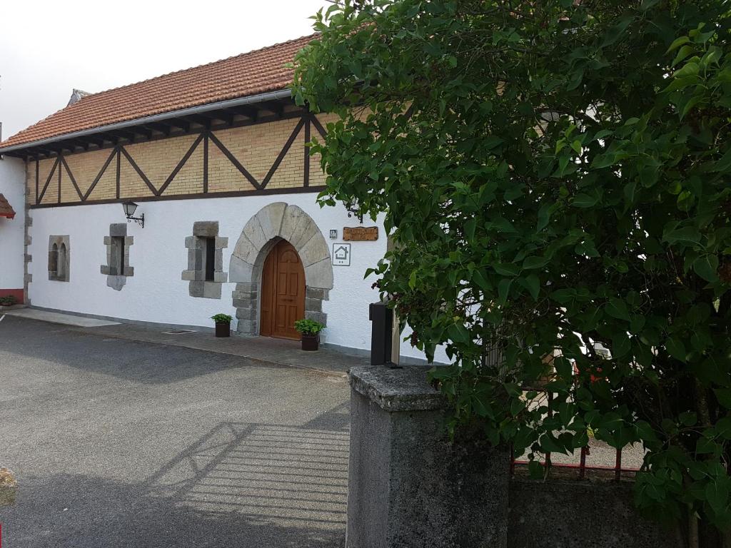 埃斯皮纳尔奥泽皮利Casa Rural Oihan - Eder的白色的建筑,有棕色的门和一棵树