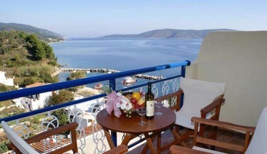 KalamakiaAgnanti Hotel的阳台设有一张桌子,享有海景。