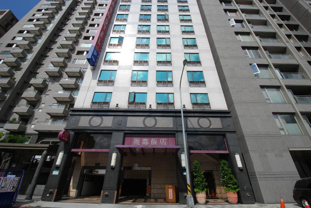 台北丽都唯客乐饭店的一座高大的白色建筑,前面有一个门