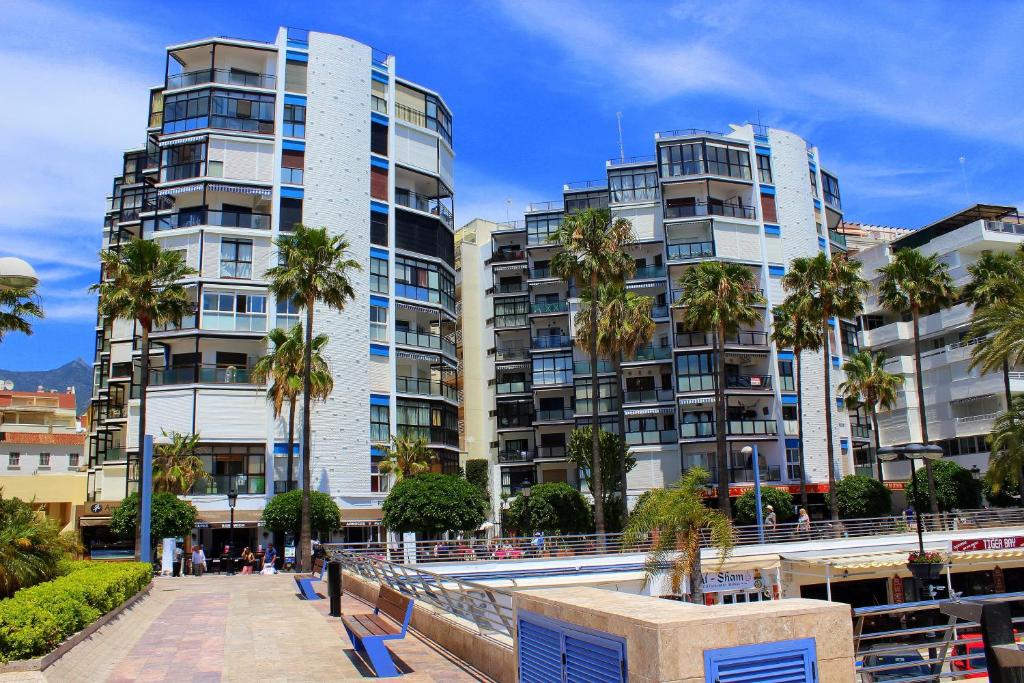 马贝拉Estudio Puerto Deportivo Marbella的前面一排种有棕榈树的高楼