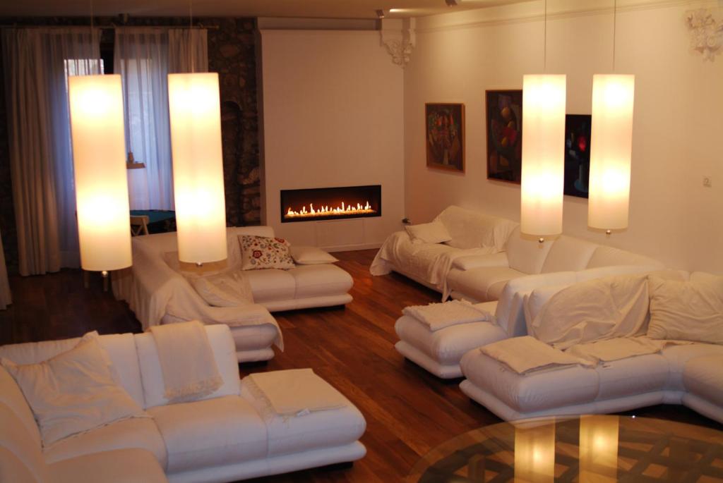 拉波夫拉-德利列特El Castell de la Pobla de Lillet (Adults Only)的客厅配有白色沙发和壁炉