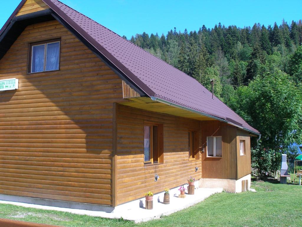 奥什恰德尼察Chalupa Iveta的小木屋设有红色屋顶和门廊