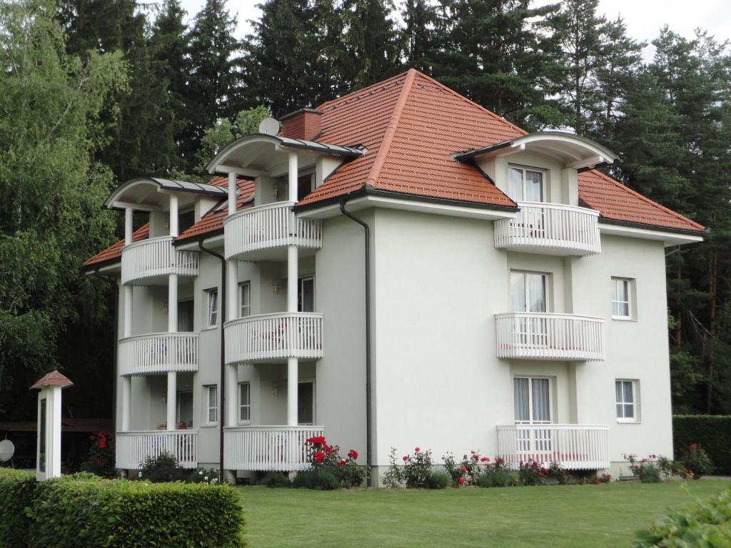 圣卡尼兹弗瑞恩瓦豪昂罗盖特斯酒店的一座白色的大公寓楼,设有红色屋顶