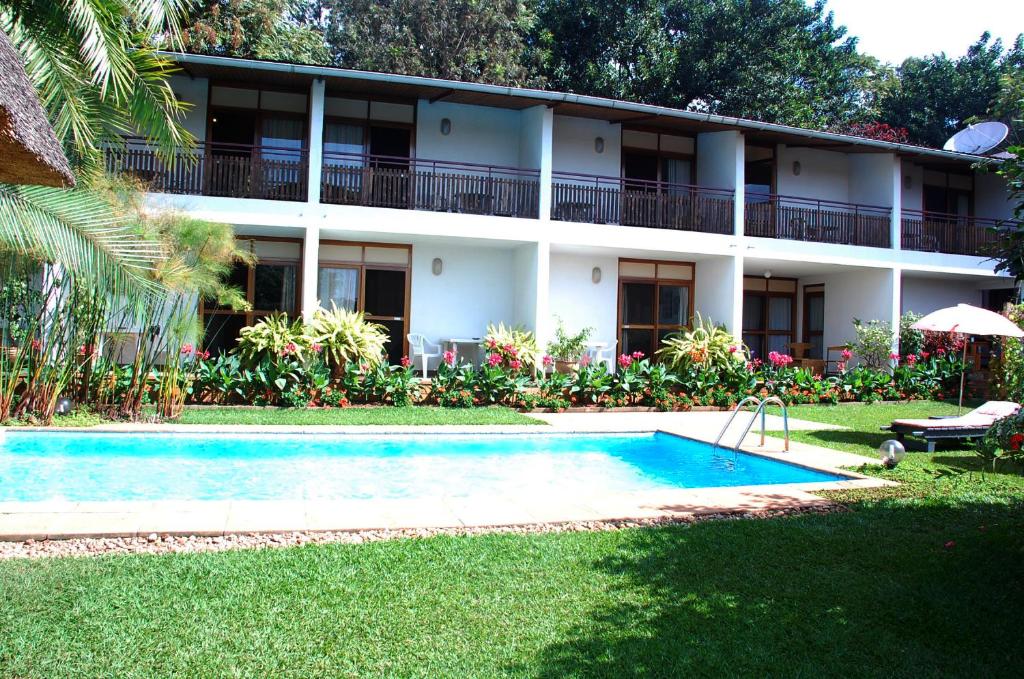 基加利勒加尼酒店的一座带游泳池的度假村,位于一座建筑前