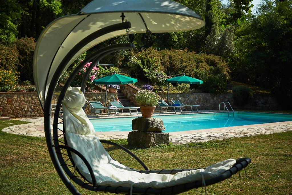 基安蒂盖奥勒La Loggetta - Chianti apartments的坐在游泳池旁椅子上的女人的雕像