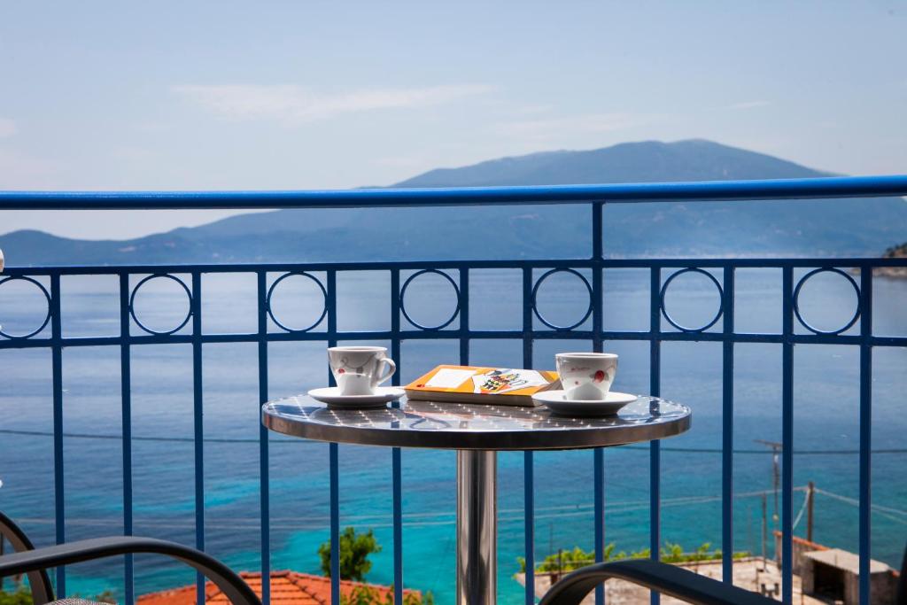 阿依亚埃夫菲亚橄榄湾酒店的阳台上的桌子和两杯,书