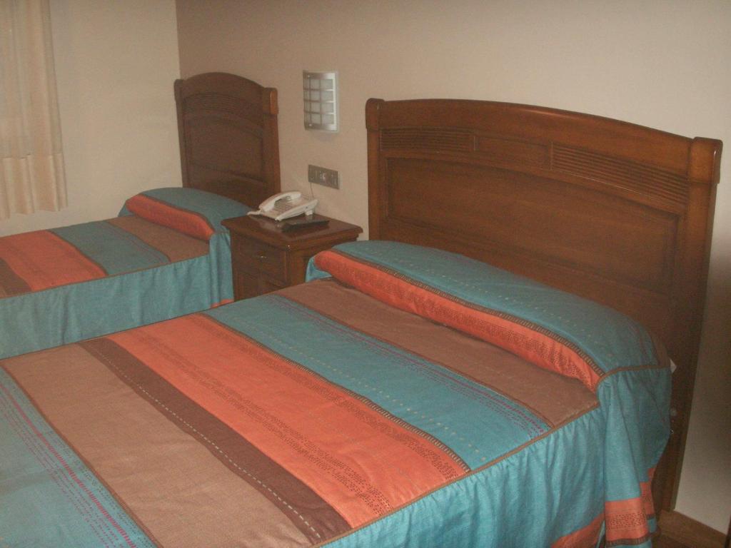 马德里拉纳瓦旅舍的一间卧室配有两张床,内配电话