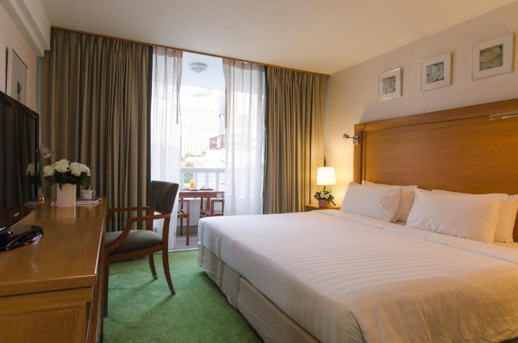 曼谷AT EASE saladaeng by AETAS的酒店客房设有一张大床和一张书桌。