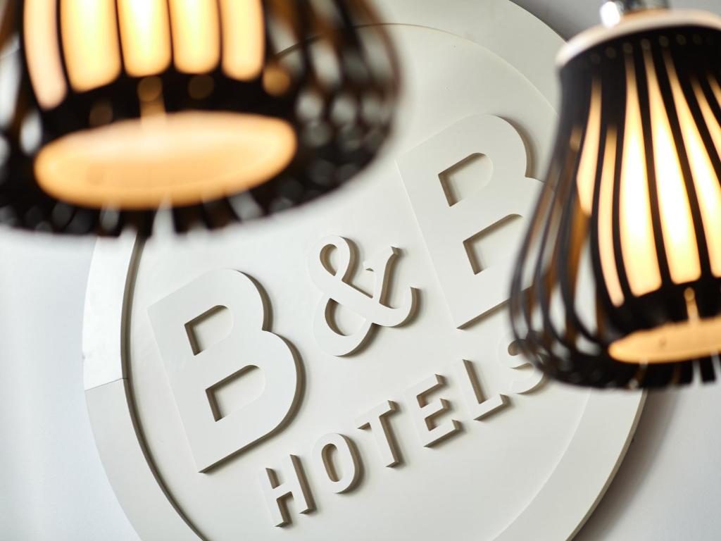 翁弗勒尔B&B HOTEL Honfleur的两盏灯在盘子上,上面有一块弧形标志