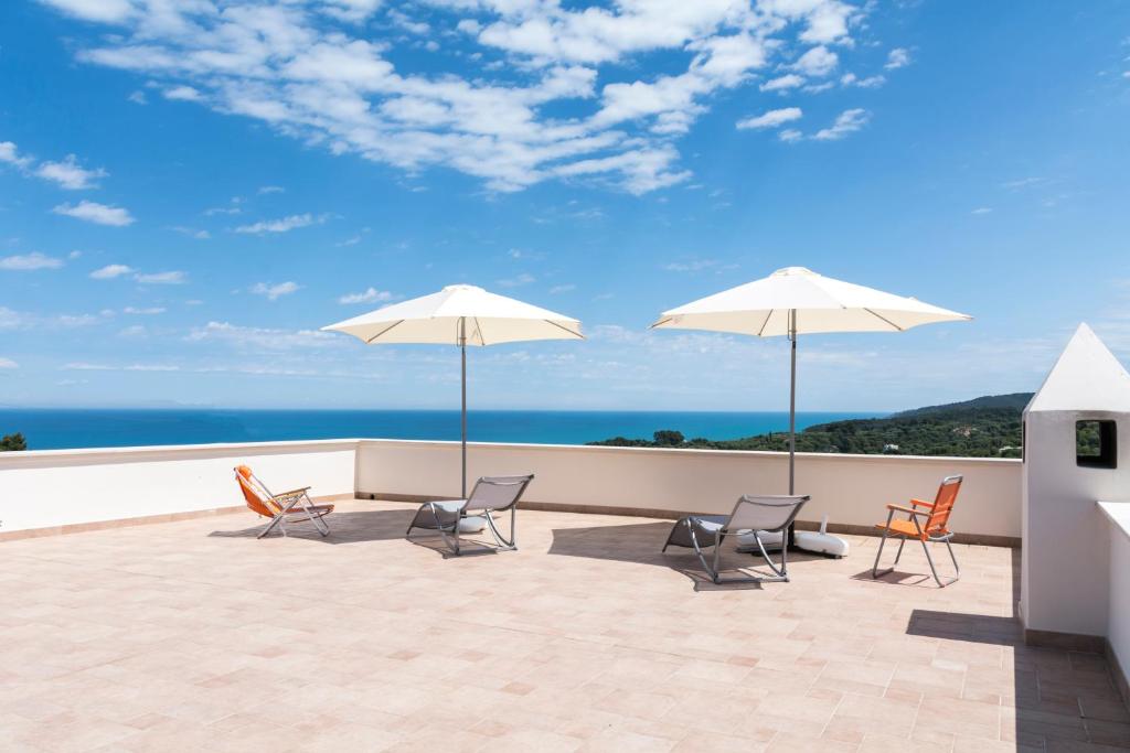罗迪-加尔加尼科Il Melangolo的一个带椅子和遮阳伞的庭院和大海