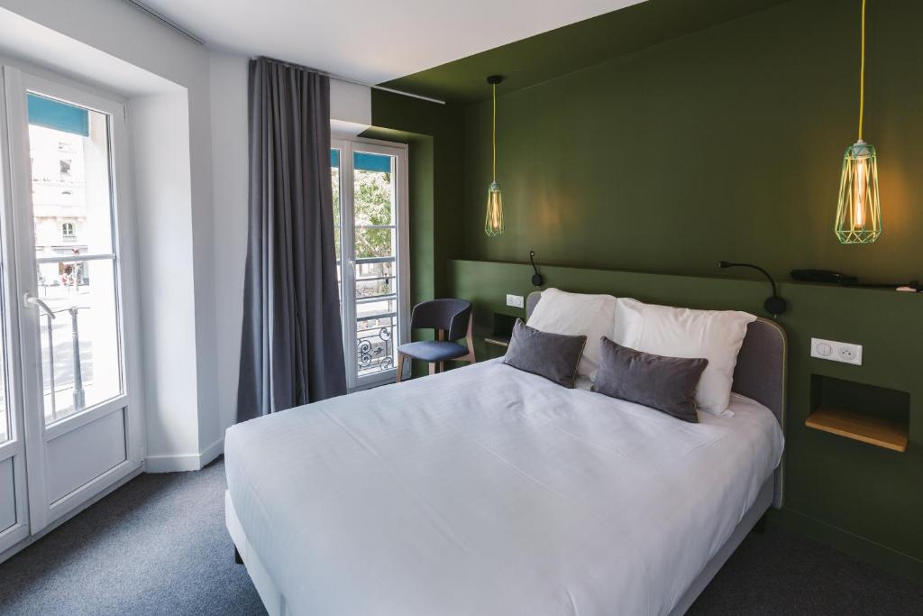 巴黎小型舒适酒店的卧室配有白色的床和绿色的墙壁