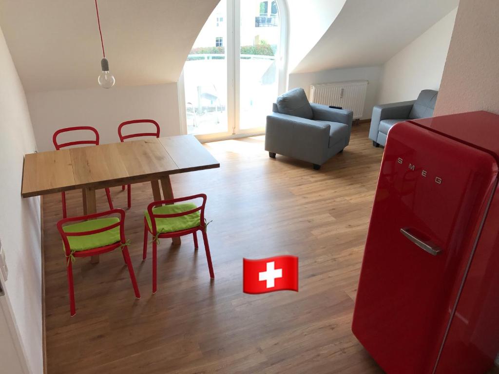 鲁斯特SWISS LOFT by Europa-Park - EP Ticket Garantie的客厅配有红色冰箱和桌椅