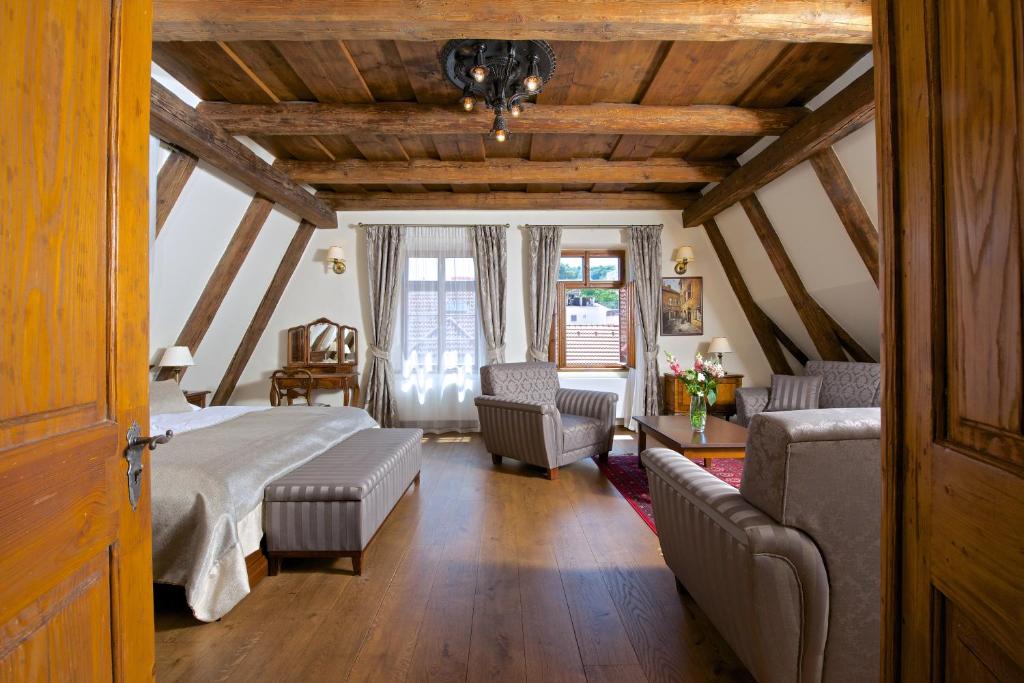 布拉格优梅森纳瑟公寓式酒店的一间卧室配有一张床、一张沙发和椅子