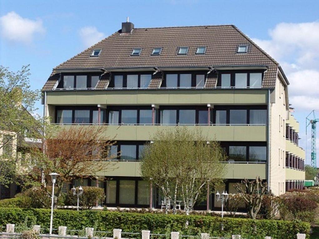 比苏姆Strandresidenz-Rosengarten-Wohnung-Nr-108的一栋大型公寓楼,设有棕色屋顶