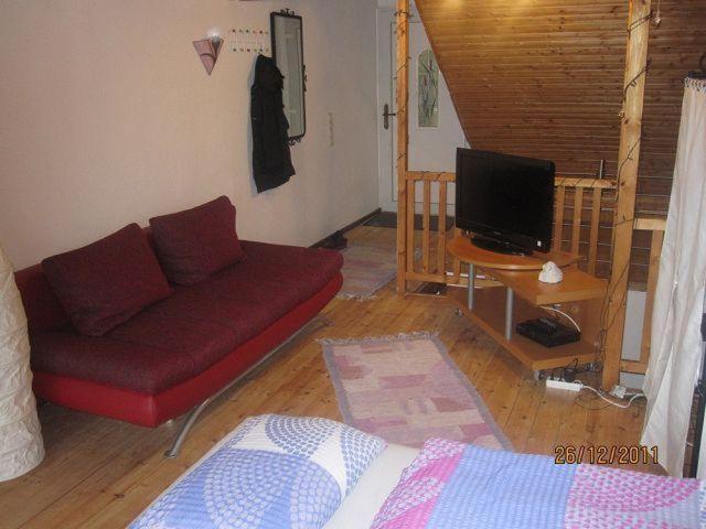 布兰肯海姆Ferienwohnungen-Willrich-Ferienwohnung-2的客厅配有红色沙发和电视