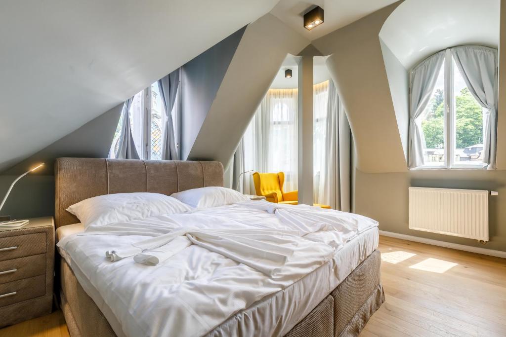 卡罗维发利波希米亚狂想曲公寓的一间卧室配有一张带白色床单的大床