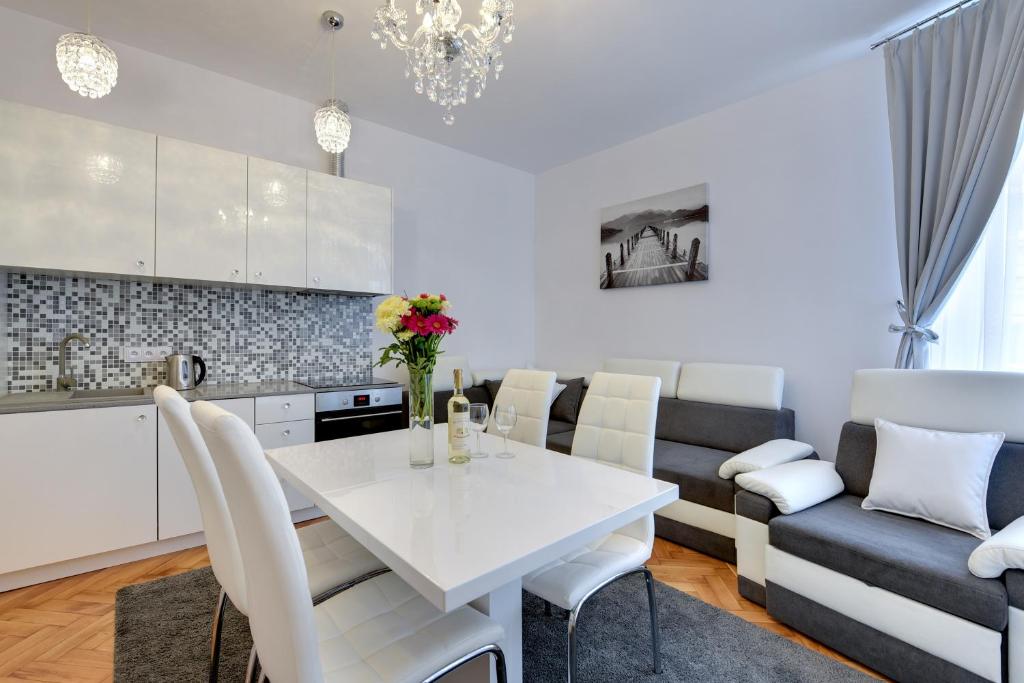 索波特Platinum Chmielewskiego的厨房以及带白色桌椅的用餐室。